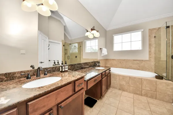 a bathroom with a granite countertop sink a toilet a mirror and bathtub