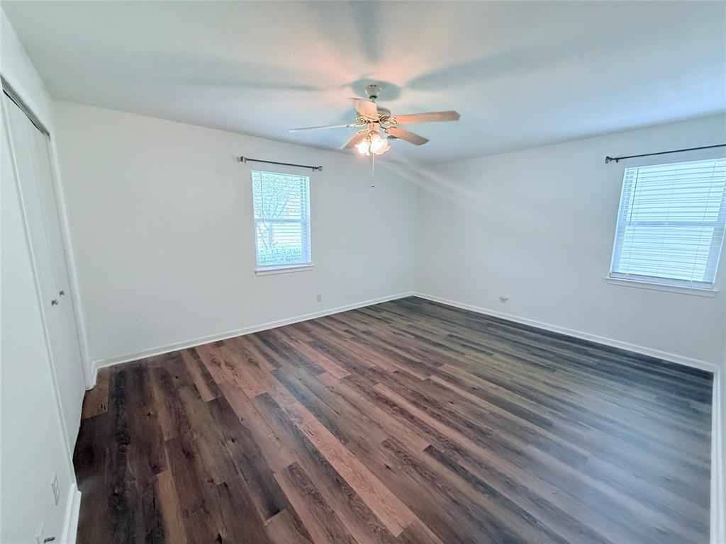 160 Bob White Road Denison, TX 75020 - Photo 19 of 29 Spacious interior featuring wood-finish flooring, two windows with blinds, a ceiling fan with integrated lighting, and a bi-fold closet door
