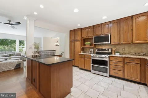 a kitchen with stainless steel appliances granite countertop a refrigerator stove top oven and sink