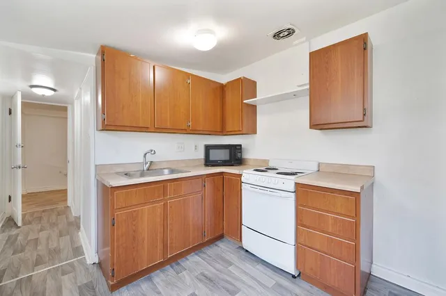 a kitchen with a stove top oven sink and cabinets