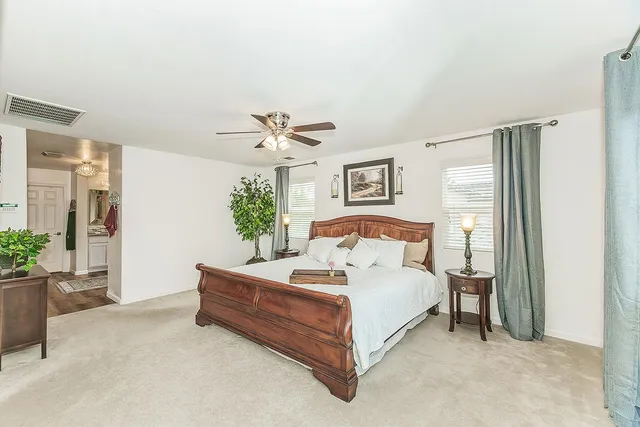 a bathroom with a granite countertop toilet a sink a mirror a shower and a window