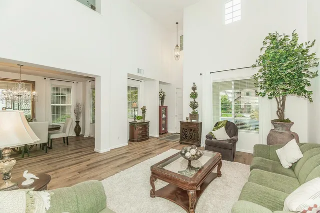 a living room with furniture and a dining table with wooden floor