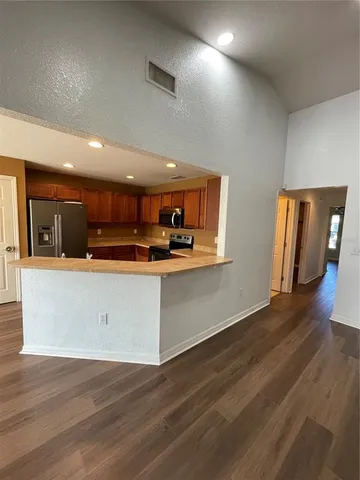 an open kitchen with a sink and dishwasher with wooden floor