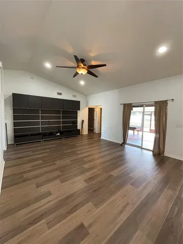 a view of room with wooden floor and ceiling fan