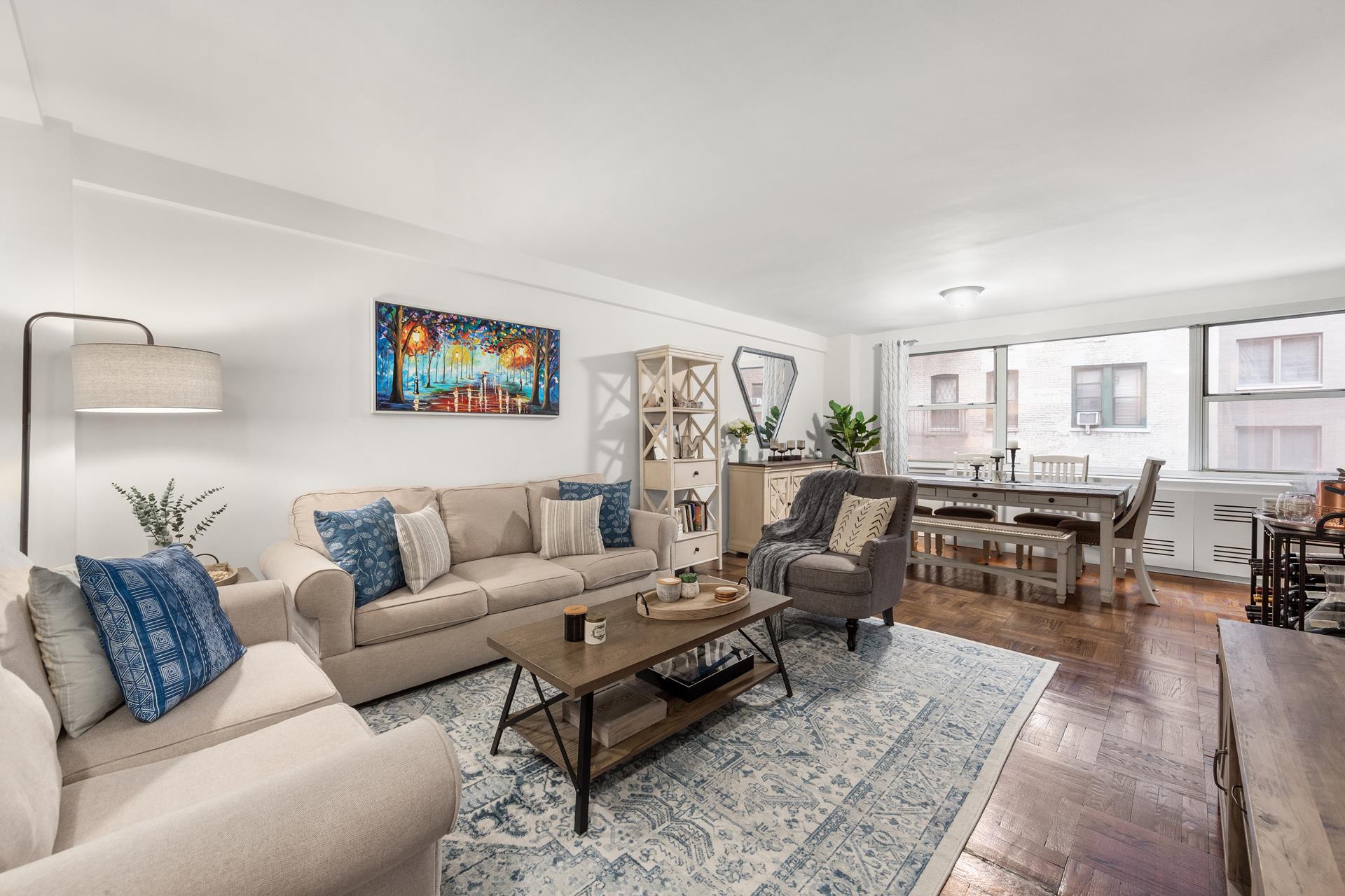 a living room with furniture wooden floor and kitchen view