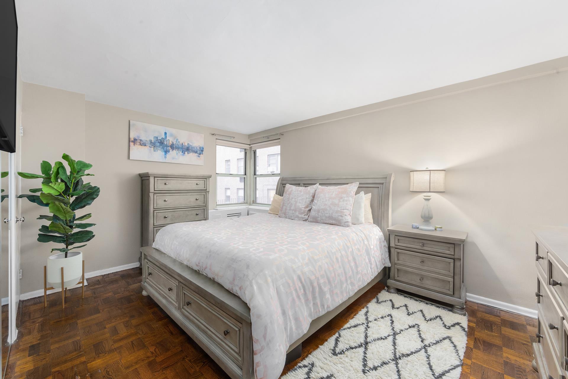 233 East 69th Street, Unit 2A Manhattan, NY 10021 - Photo 4 of 8 a bedroom with a bed and a potted plant