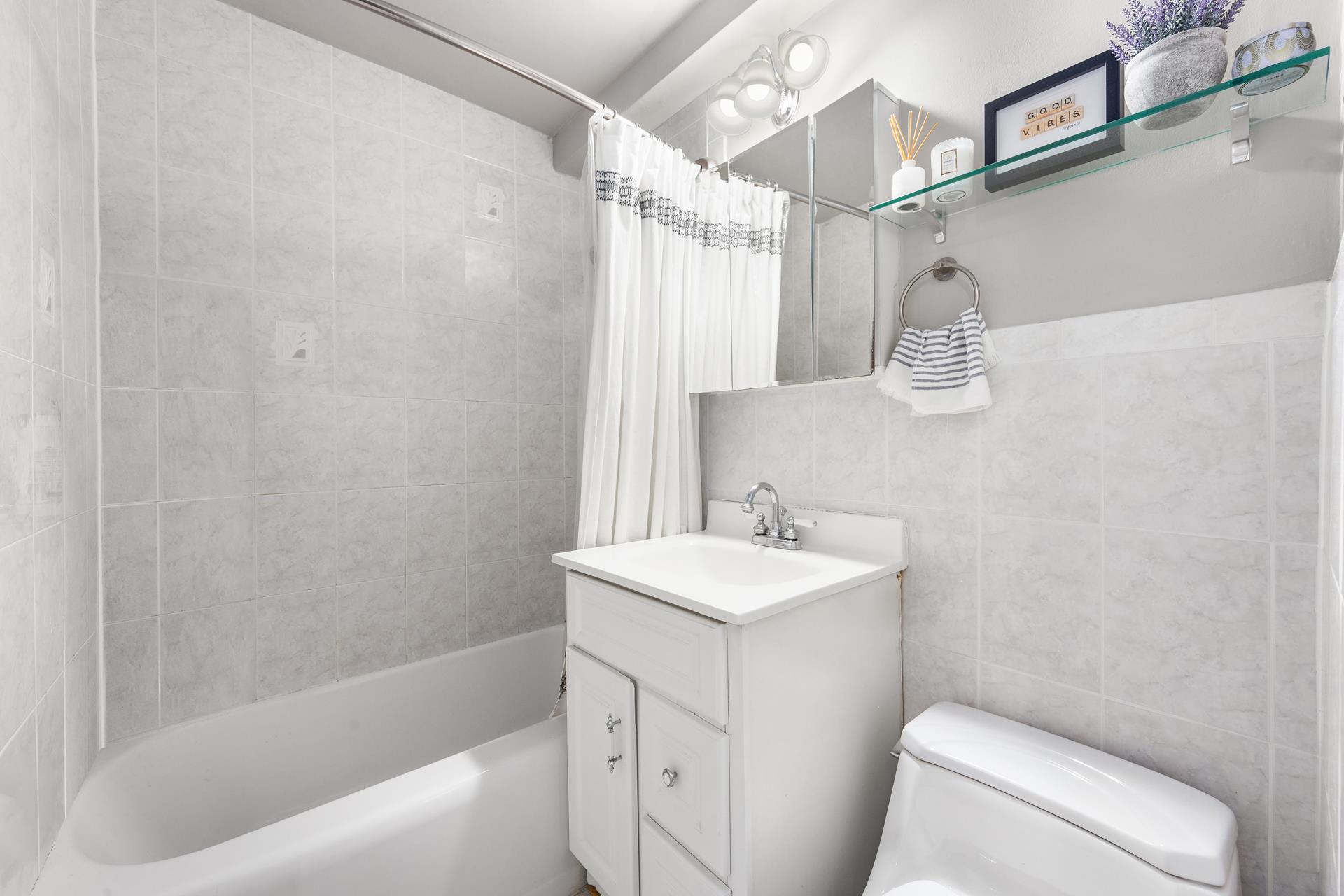 233 East 69th Street, Unit 2A Manhattan, NY 10021 - Photo 5 of 8 a bathroom with a sink a toilet and shower