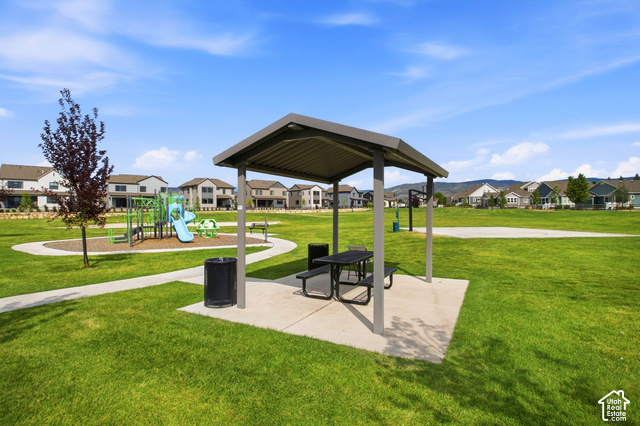 986 South Old Farm Road Heber City, UT 84032 - Photo 45 of 51 Community park featuring a spacious open lawn, covered picnic shelter with integrated seating and dining surface, concrete pads, trash receptacle, and mature landscaping with established trees throughout the grounds