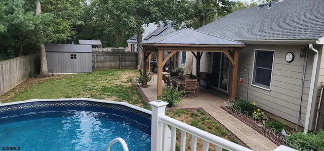 a view of a small house next to a yard