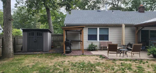 a backyard of a house with table and chairs