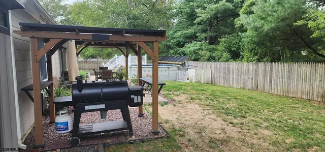 a view of backyard with table and chairs and wooden fence