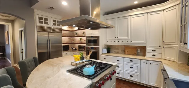 a kitchen with stainless steel appliances kitchen island granite countertop a stove refrigerator and microwave