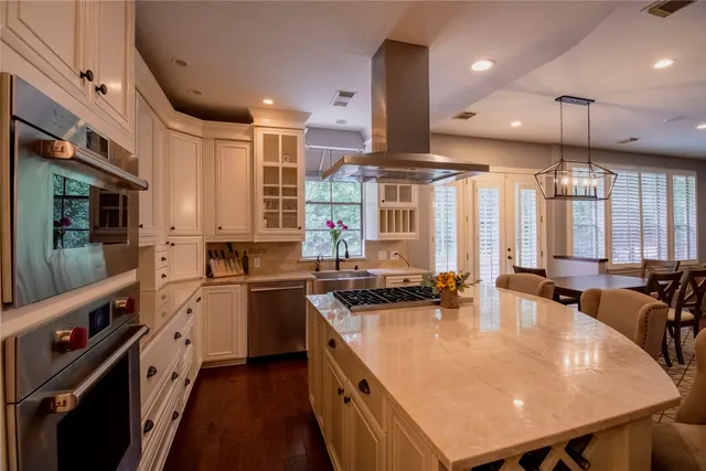 a kitchen with stainless steel appliances granite countertop a sink a stove and a refrigerator