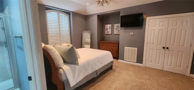 a bed room with a bed a television and a window