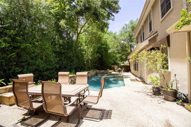 a view of backyard with swimming pool and sitting area
