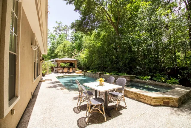 a patio with table and chairs and potted plants
