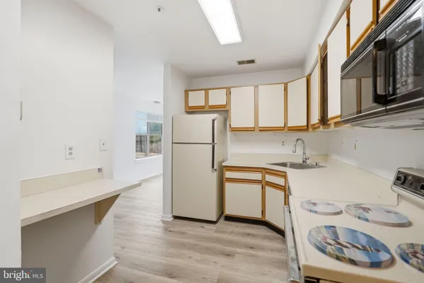 a kitchen with a sink a refrigerator and cabinets