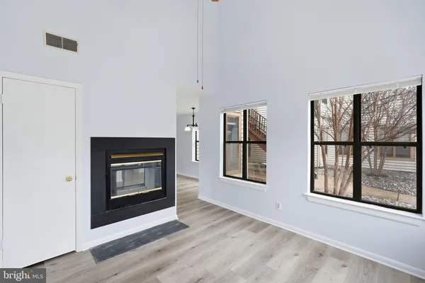 a view of an empty room with glass door and windows