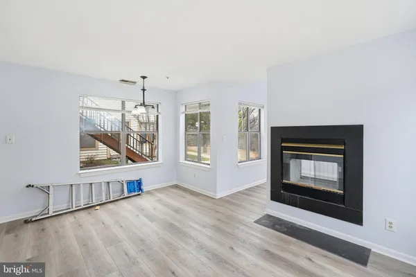 a view of an empty room with a fireplace and a window