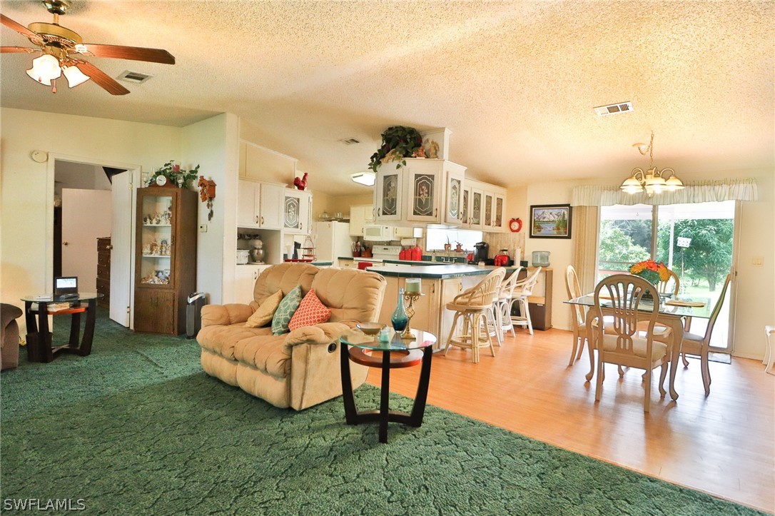 2671 Packinghouse Road Alva, FL 33920 - Photo 15 of 24 a living room with furniture a dining table and a large window