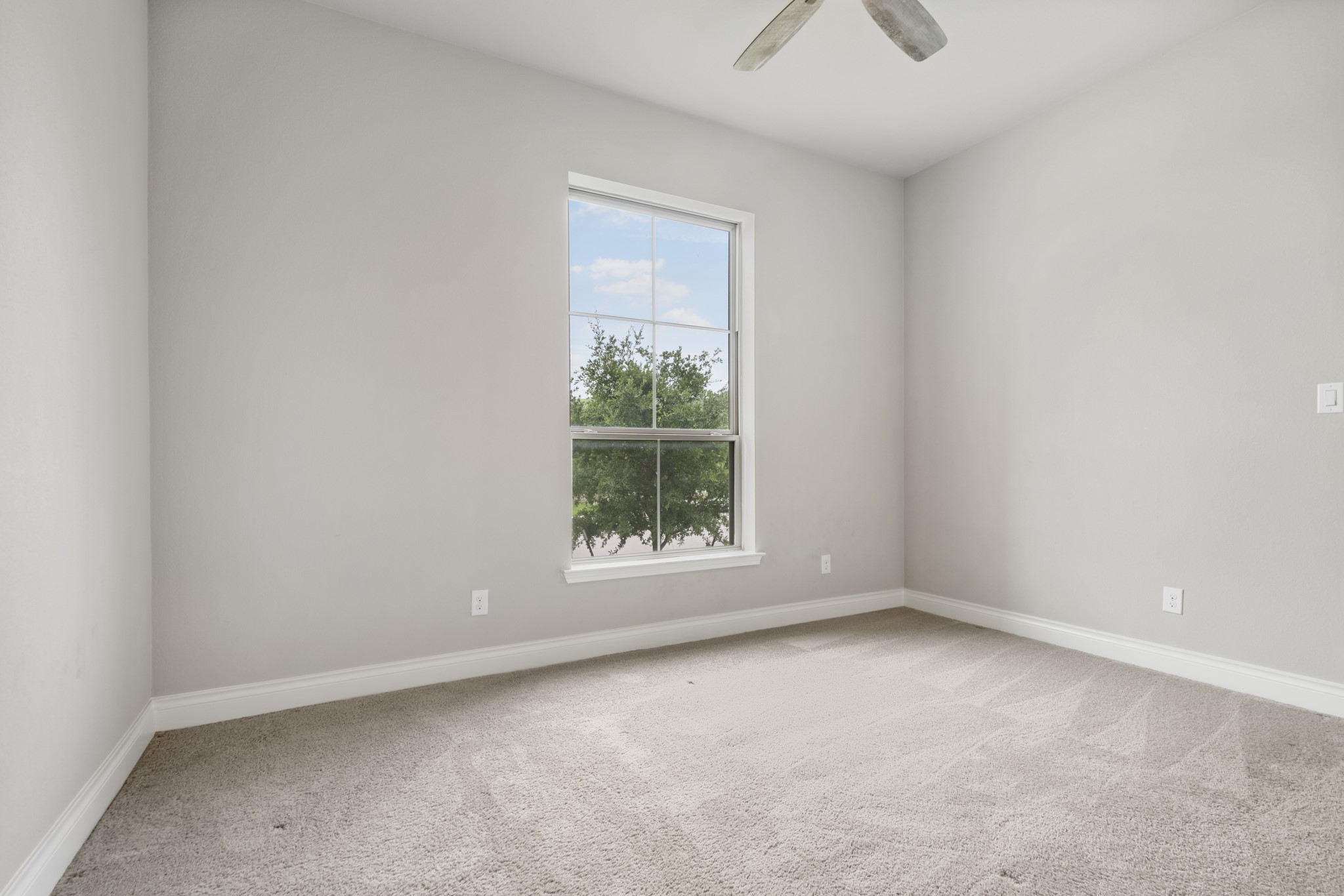 104 Catani Loop Georgetown, TX 78628 - Photo 17 of 34 This room features neutral-toned walls, carpeted flooring, and a window providing natural light and a view of trees