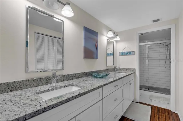 a bathroom with a granite countertop sink and a mirror
