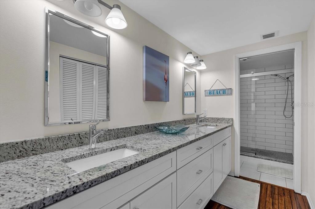 5621 Gulf Of Mexico Drive, Unit 102 Longboat Key, FL 34228 - Photo 16 of 22 a bathroom with a granite countertop sink and a mirror