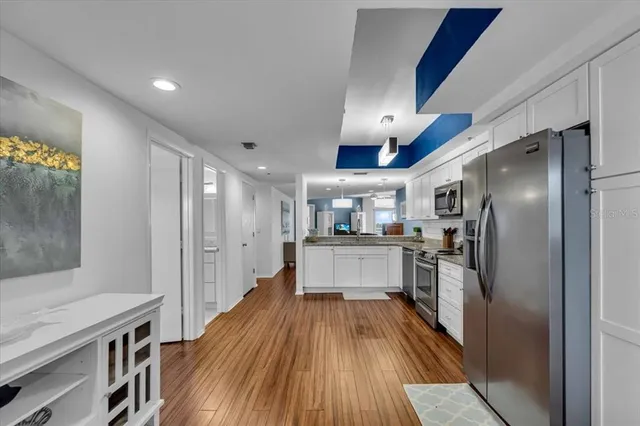 a kitchen with kitchen island wooden floor center island and stainless steel appliances