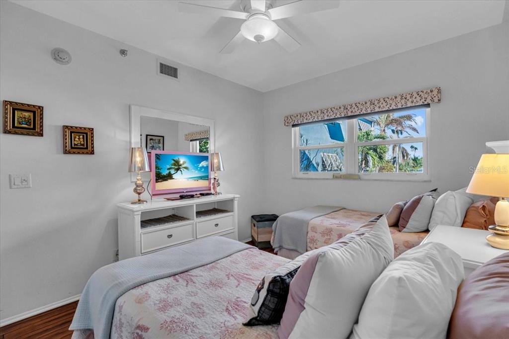 5621 Gulf Of Mexico Drive, Unit 102 Longboat Key, FL 34228 - Photo 7 of 22 a bedroom with a bed and a chandelier