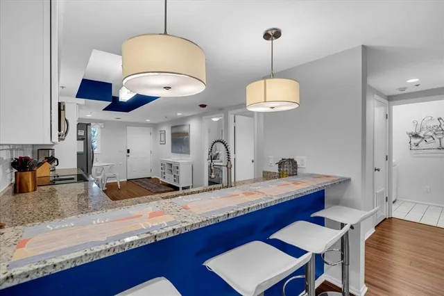 a kitchen with granite countertop a stove a sink a dining table and chairs