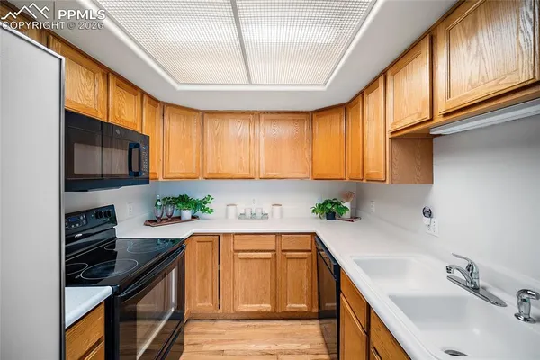 a kitchen with a sink a counter top space appliances and cabinets