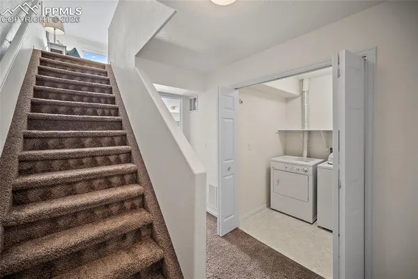 a view of entryway with wooden cabinets and stairs