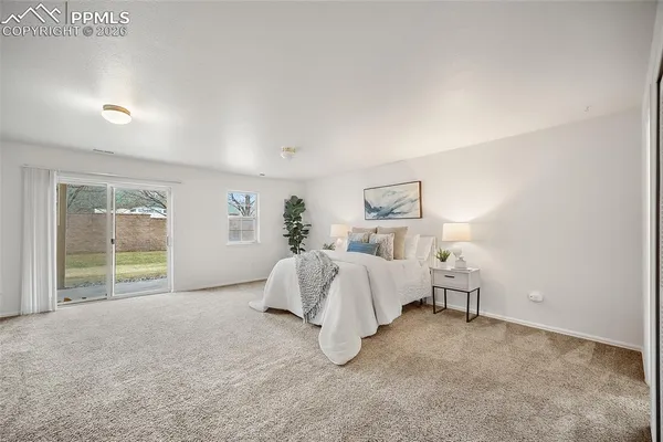 a spacious bedroom with a bed and a large window