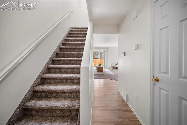 a view of a hallway with wooden floor and entryway