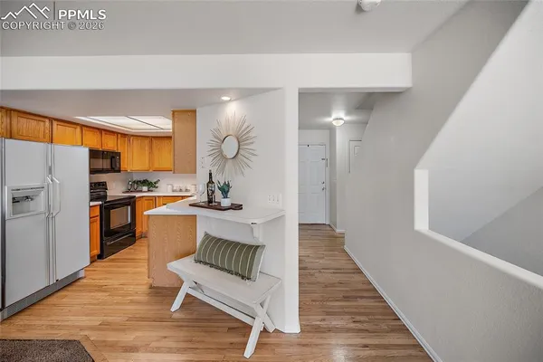 a living room with stainless steel appliances kitchen island granite countertop furniture and a wooden floor