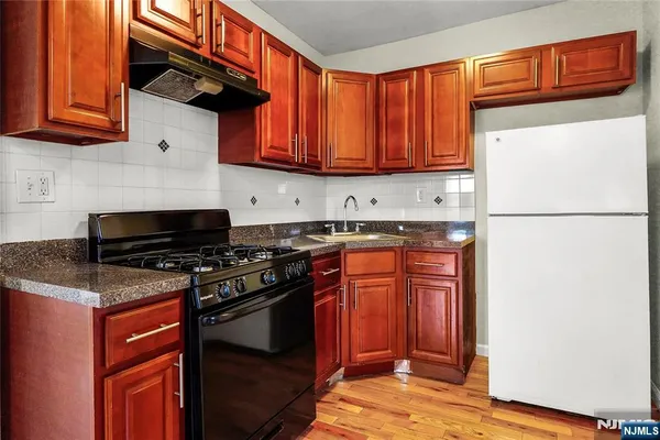 a kitchen with stainless steel appliances granite countertop a stove a refrigerator and a sink