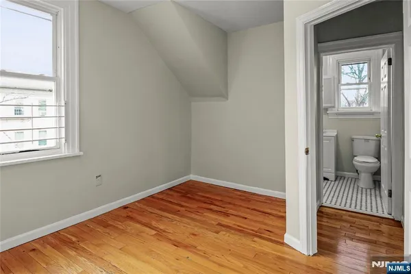 a view of a room with wooden floor and a bathroom