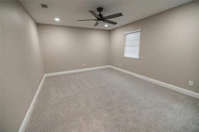 en empty room with windows and fan