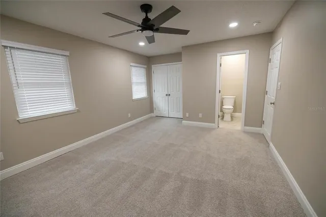 an empty room with a window and a fan