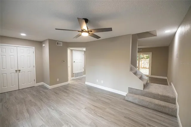 a view of an empty room with window and wooden floor