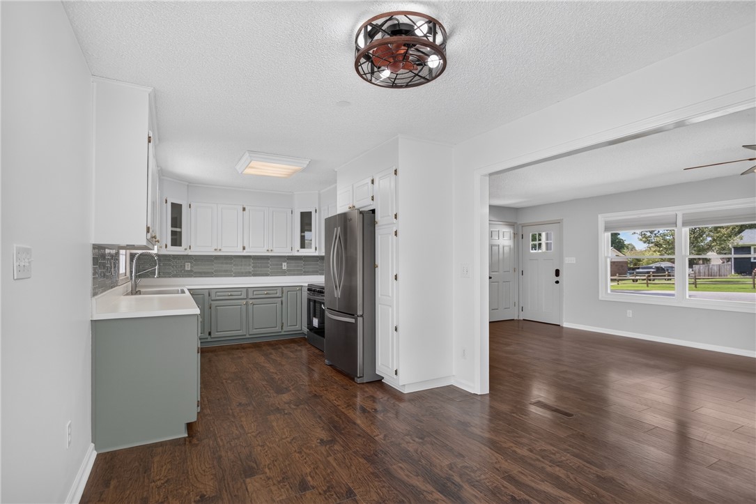 113 Greenfield Avenue Pendleton, SC 29670 - Photo 13 of 40 A well-lit kitchen with sleek appliances seamlessly flows into a spacious living area featuring rich hardwood flooring.