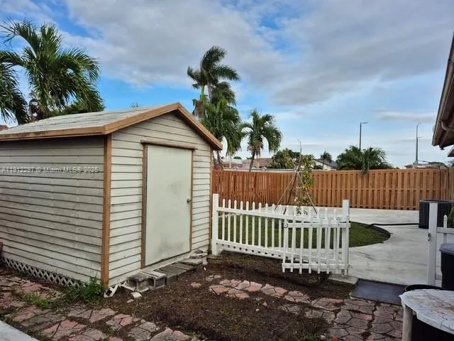 a view of a house with a small yard and wooden fence