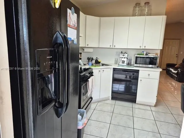 a kitchen with a refrigerator a stove top oven and cabinets