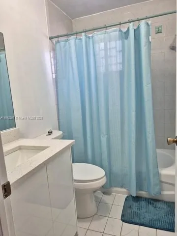 a bathroom with a sink a toilet a window and shower