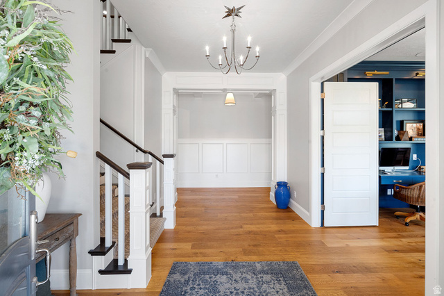 2917 Old Farm Road Washington, UT 84780 - Photo 50 of 105 Foyer entrance with a decorative wall, light wood finished floors, a wainscoted wall, ornamental molding, and suspended lighting