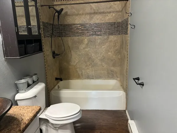 a white toilet sitting next to a bath tub and a shower