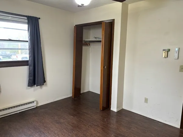 an empty room with wooden floor and a window