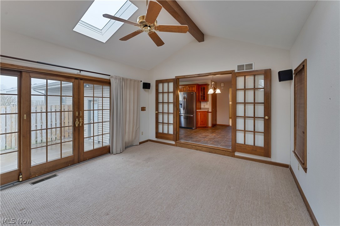 6599 Struthers Road Youngstown, OH 44514 - Photo 17 of 29 Carpeted empty room with french doors, ceiling fan, a chandelier, and a skylight