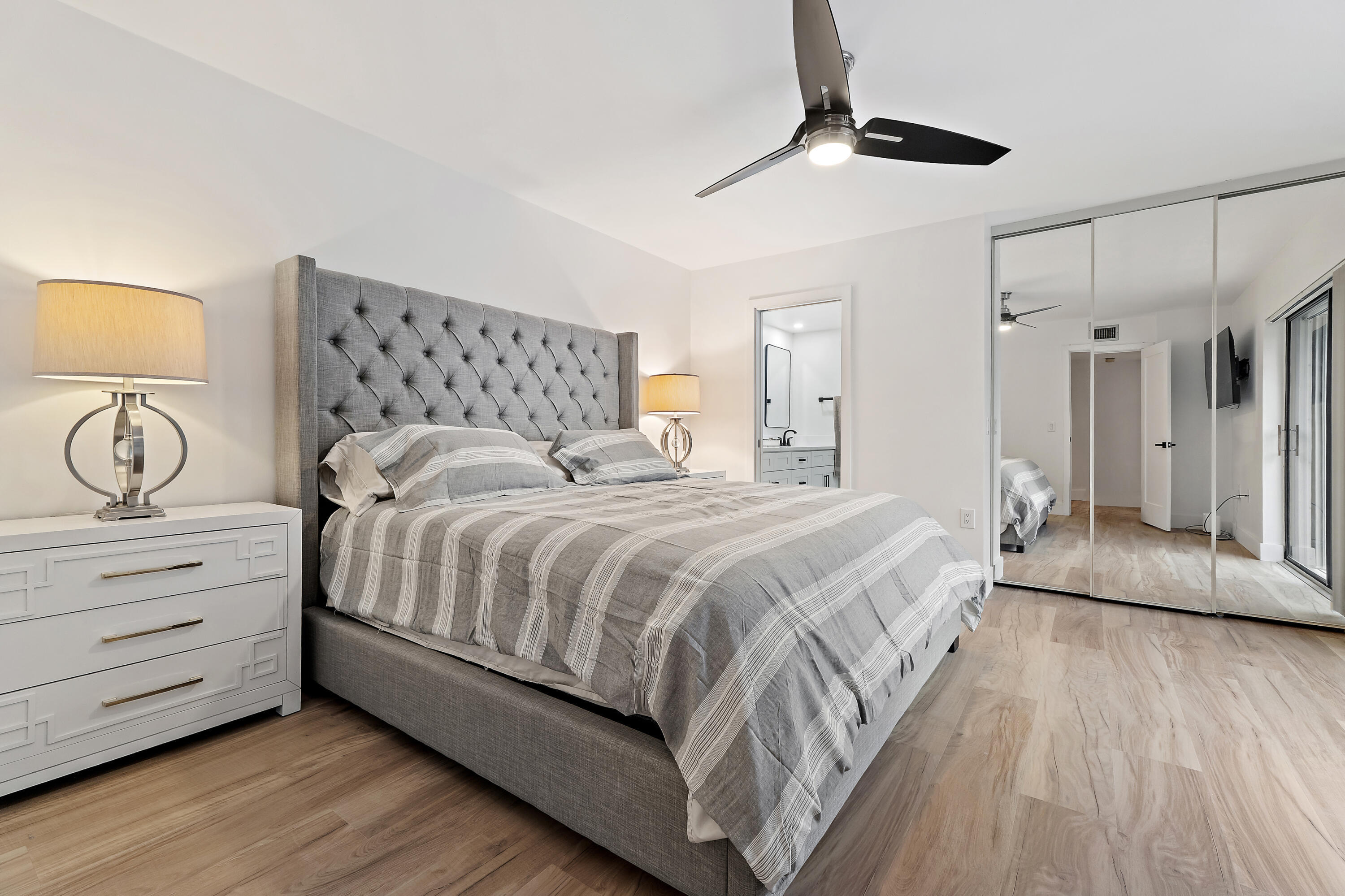 3052 30th Court Jupiter, FL 33477 - Photo 25 of 45 a bedroom with a bed and a chandelier