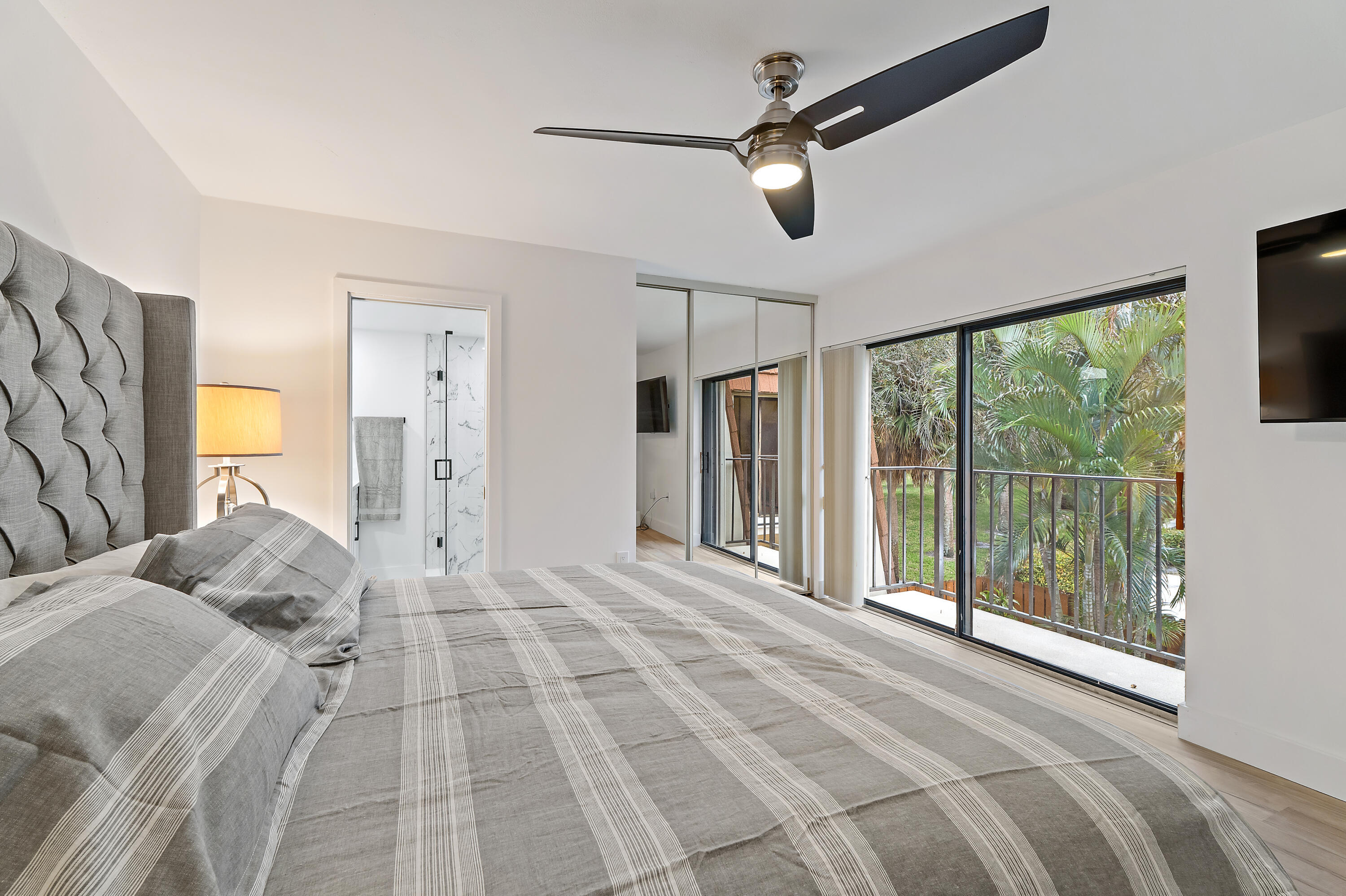 3052 30th Court Jupiter, FL 33477 - Photo 26 of 45 a bedroom with a large bed and a large window